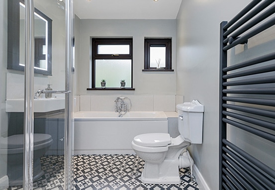 Bathroom with a bath, glass shower enclosure and patterned floor at Lower Braniel Road.